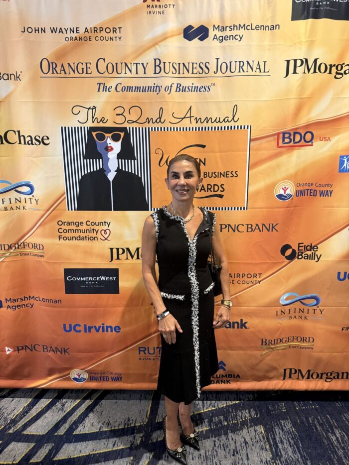Anoosheh Mostafaei-Oskouian standing in front of the Orange County Business Journal 32nd Annual Women in Business Awards backdrop